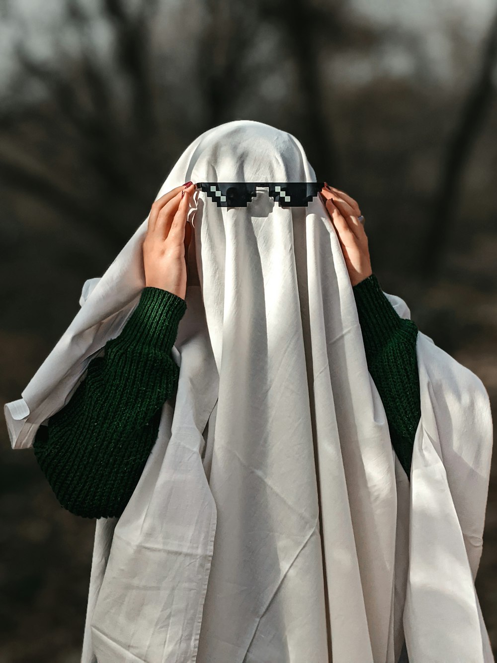 a person covering their face with a white cloth