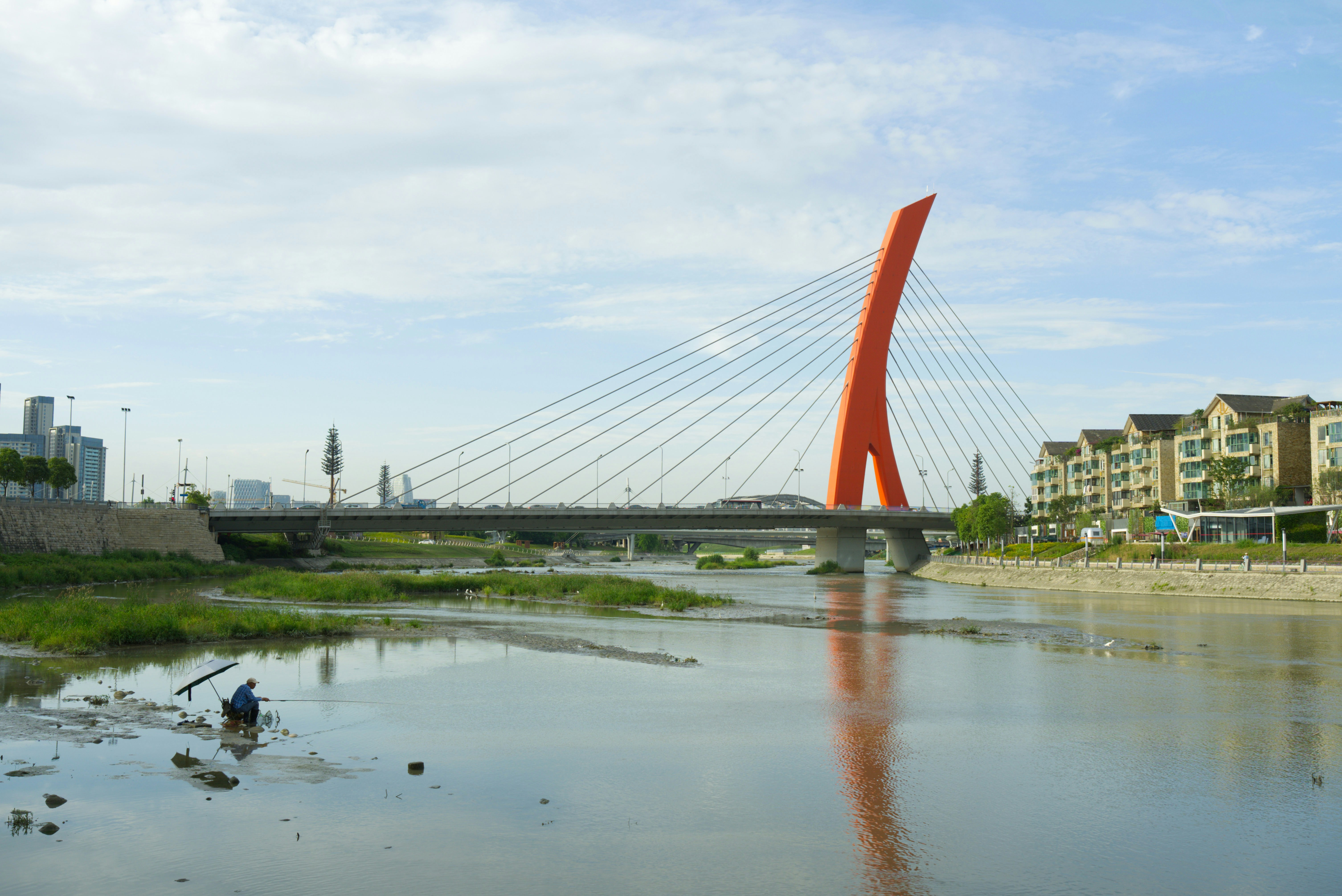 a bridge over a body of water next to a lush green field