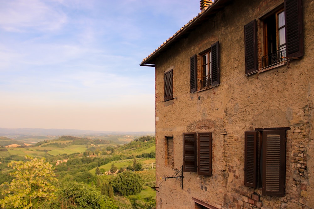 a building with shutters and a view of a valley