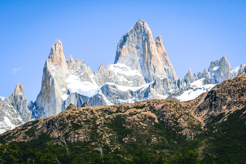 a mountain range with snow covered mountains in the background