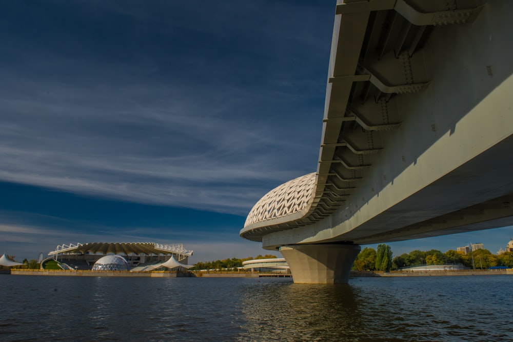 a bridge over a body of water with a building in the background