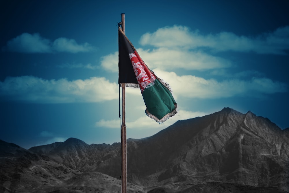 a flag on a pole with mountains in the background