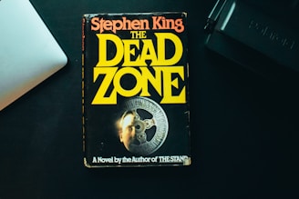 a book sitting on top of a desk next to a laptop