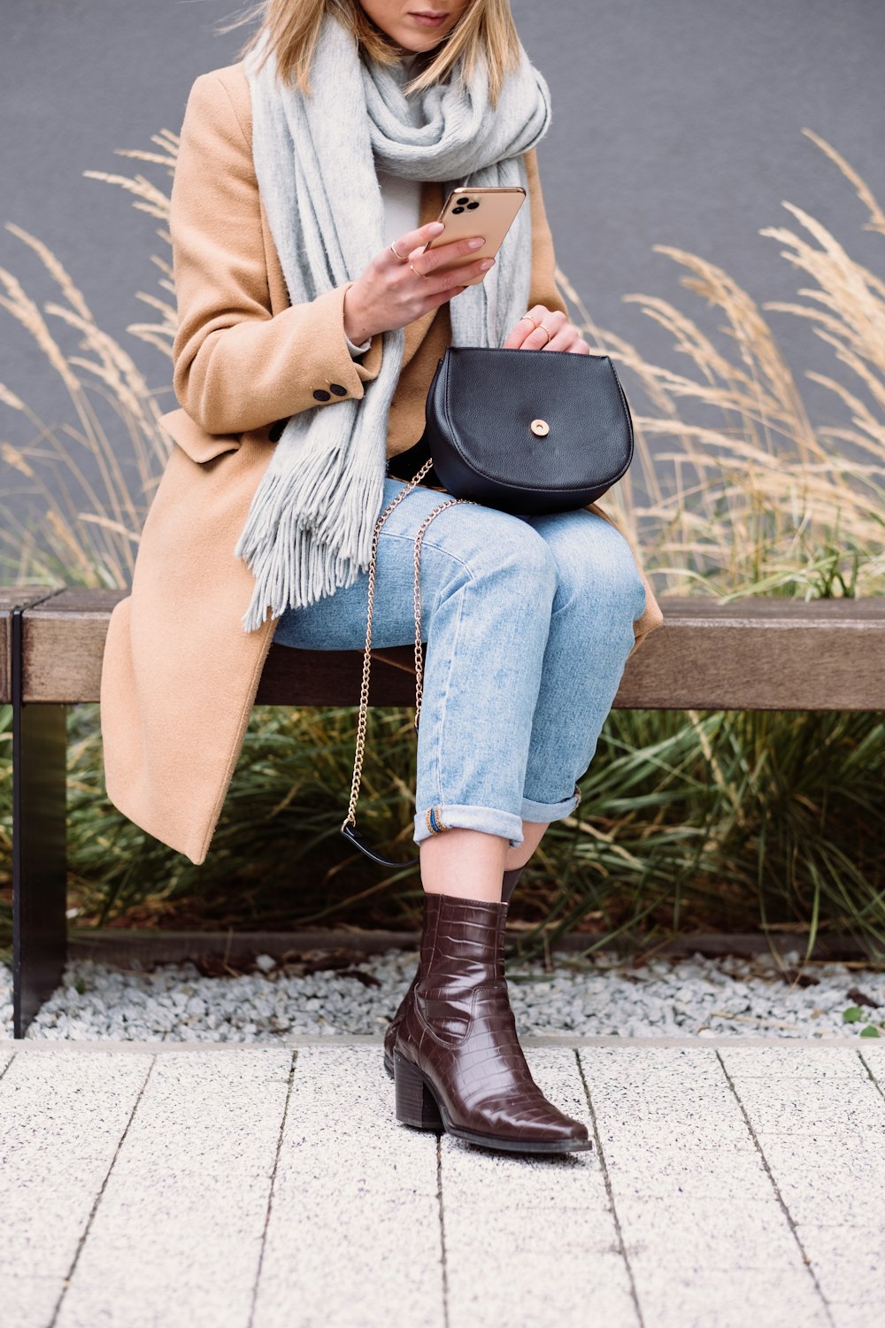 a woman sitting on a bench looking at her phone