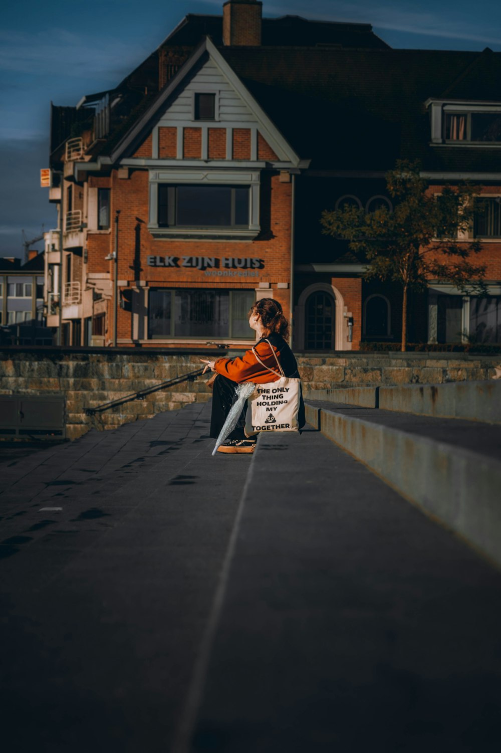 a person sitting on a ledge with a violin