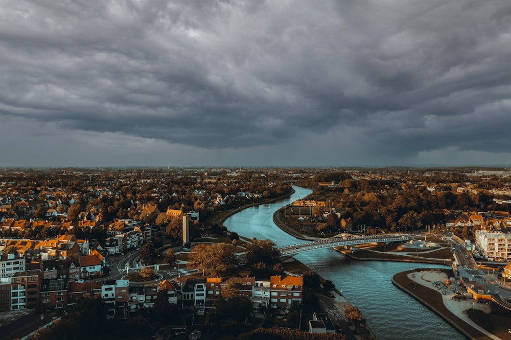 a river running through a city under a cloudy sky