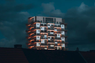 a tall building with windows lit up at night