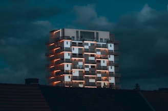 a tall building with windows lit up at night