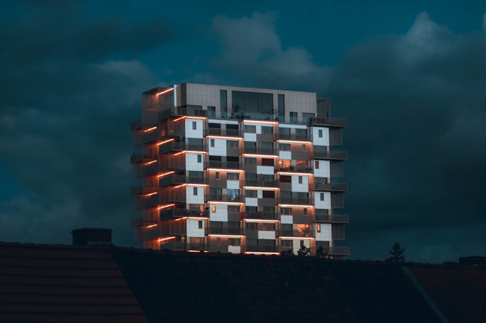 a tall building with windows lit up at night