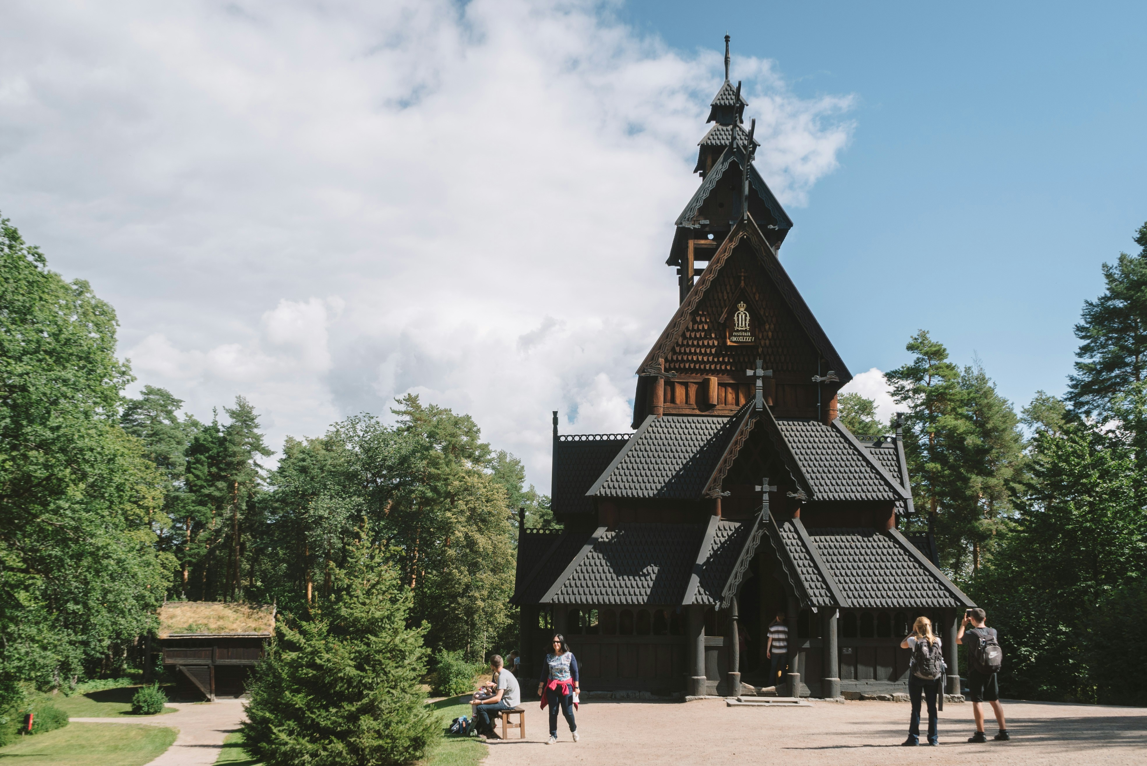 a group of people standing in front of a wooden church