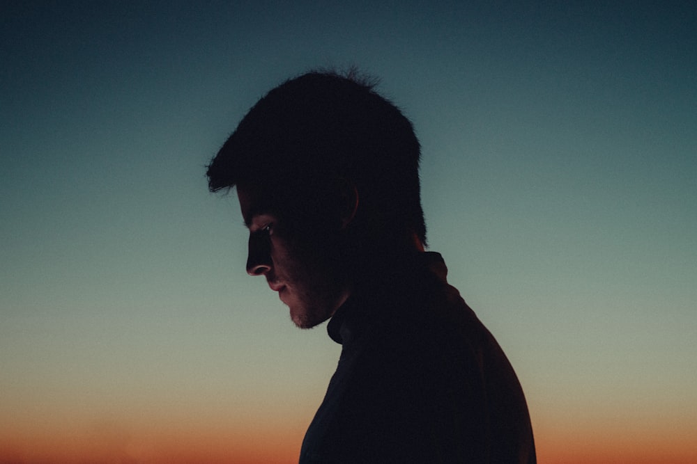 a man standing in front of a sunset