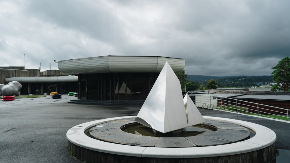 a white sculpture sitting on top of a cement circle