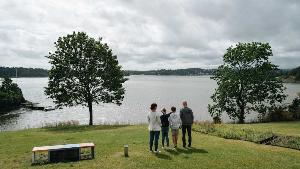 a group of people standing on top of a lush green field