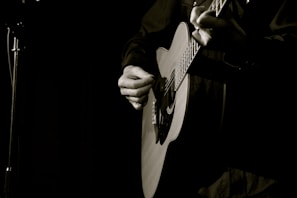 Close-up of a musician’s hands skillfully playing an acoustic guitar during an intimate live show