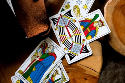 four playing cards sitting on top of a wooden table