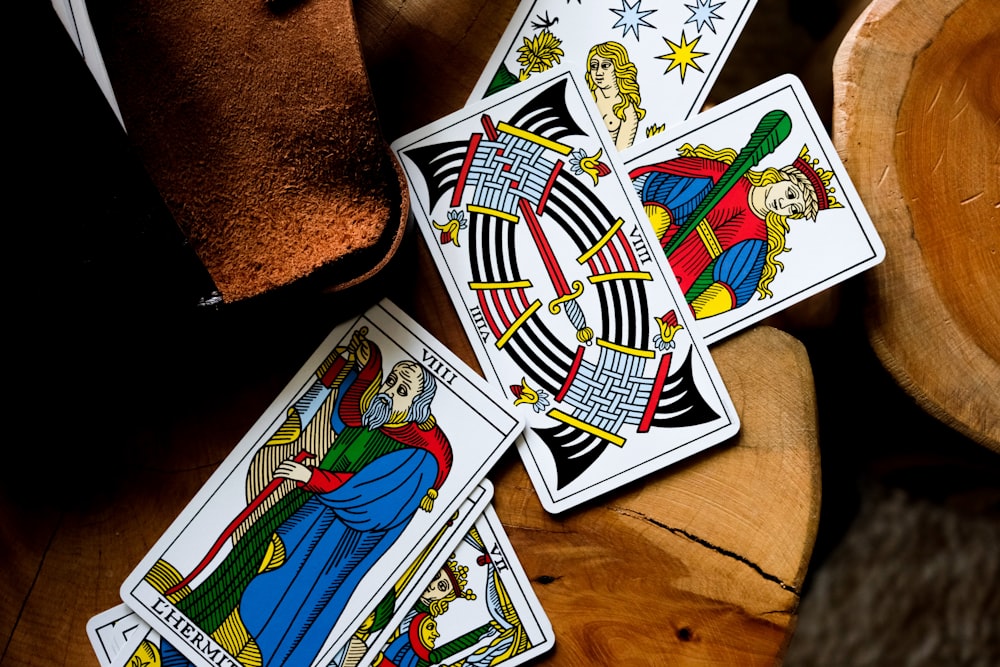 four playing cards sitting on top of a wooden table