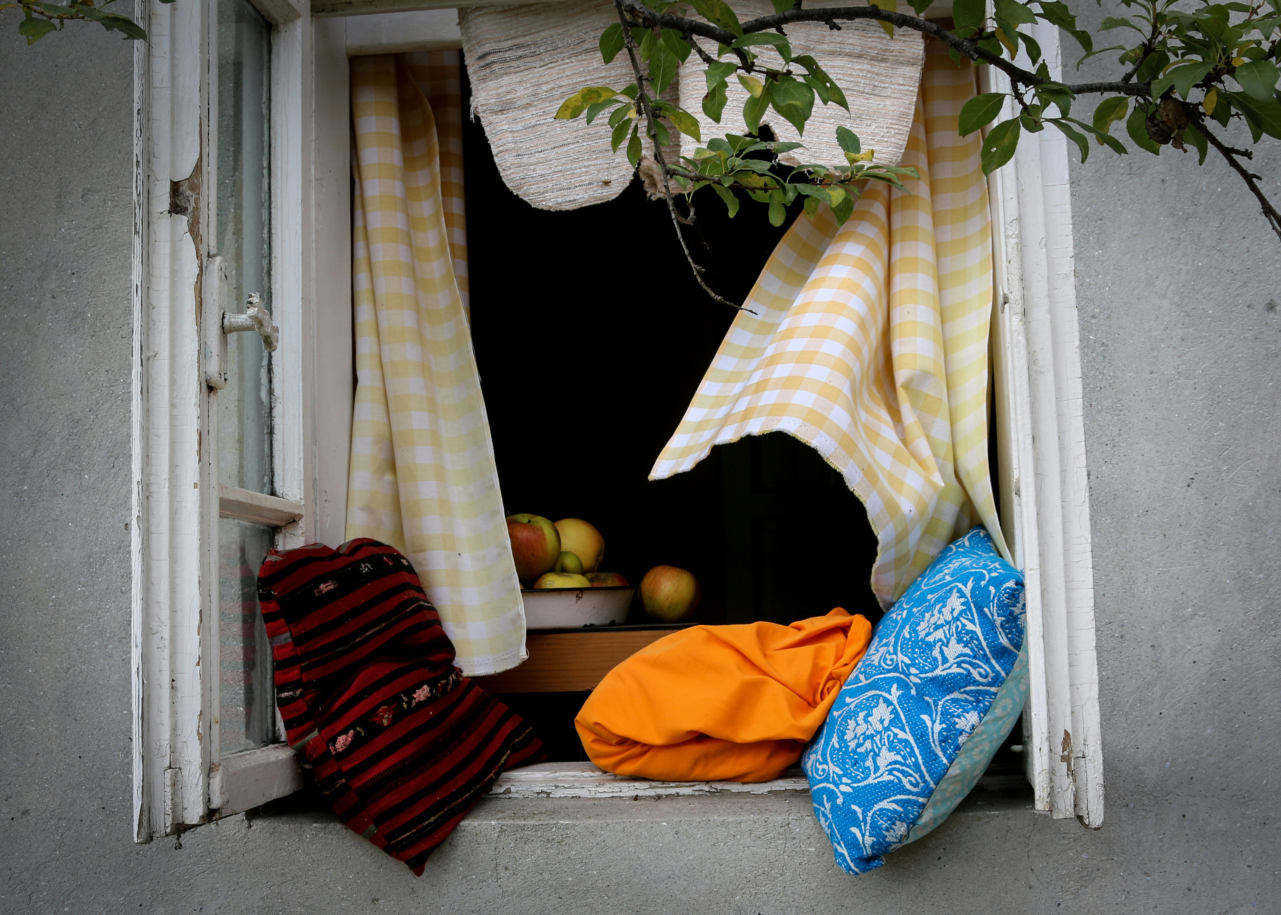 a window sill with a bunch of cloths hanging out of it
