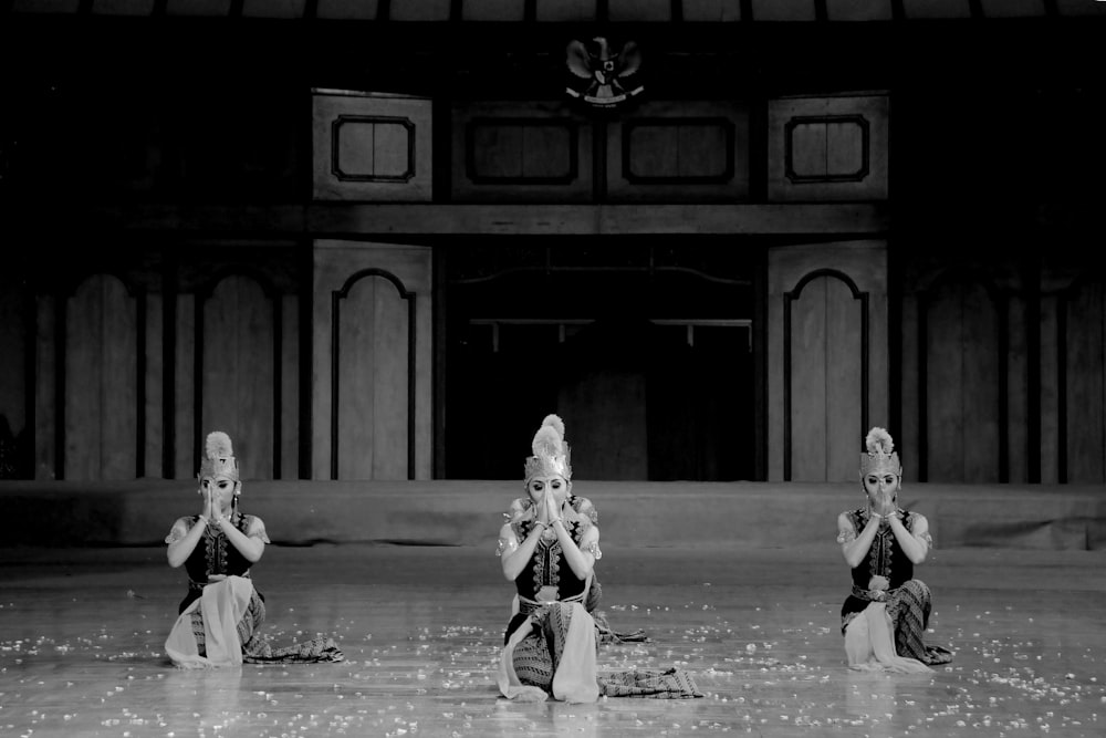 a group of women sitting on top of a dance floor