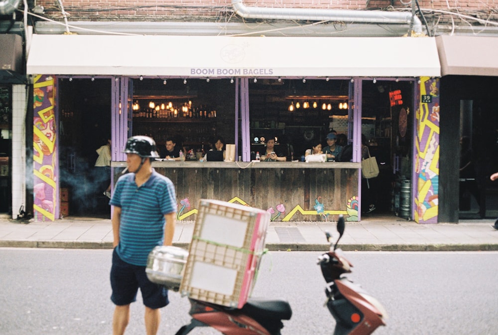 a man is walking down the street with a scooter