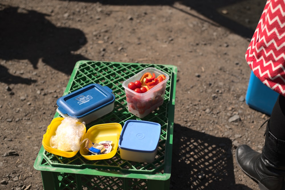 a green table topped with containers of food