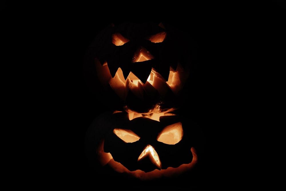 a group of jack o lantern pumpkins lit up in the dark