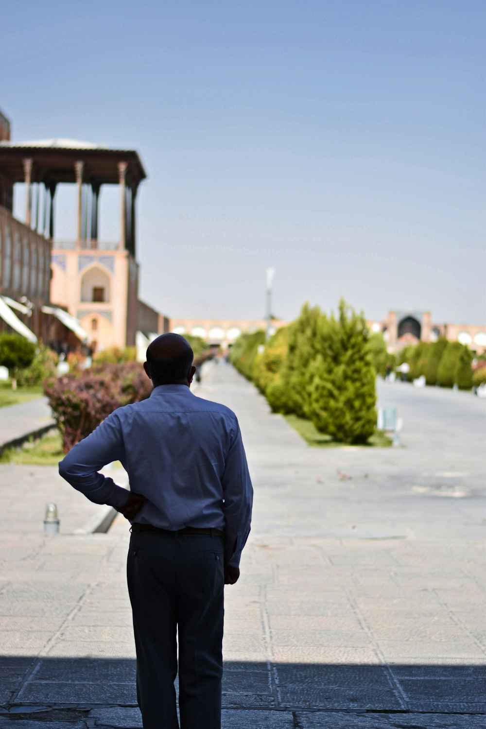 a man standing on a sidewalk with his hands on his hips