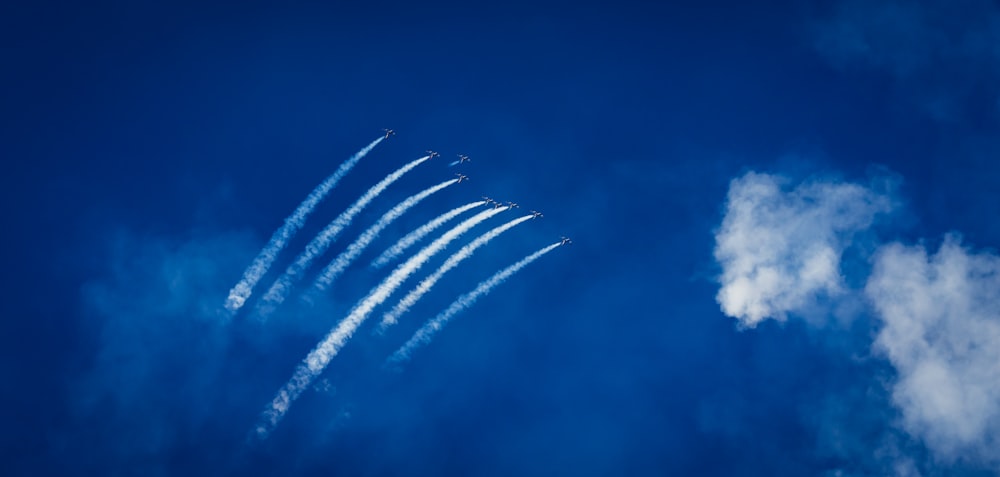 a group of airplanes flying through a blue sky