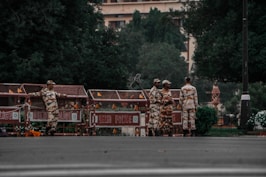 a group of men in camouflage standing in front of a building