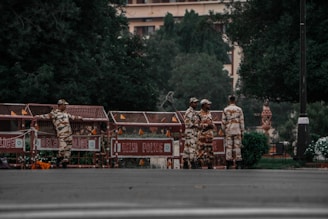 a group of men in camouflage standing in front of a building