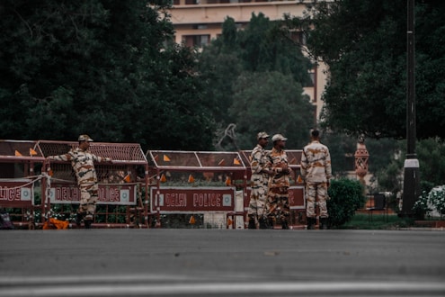 a group of men in camouflage standing in front of a building