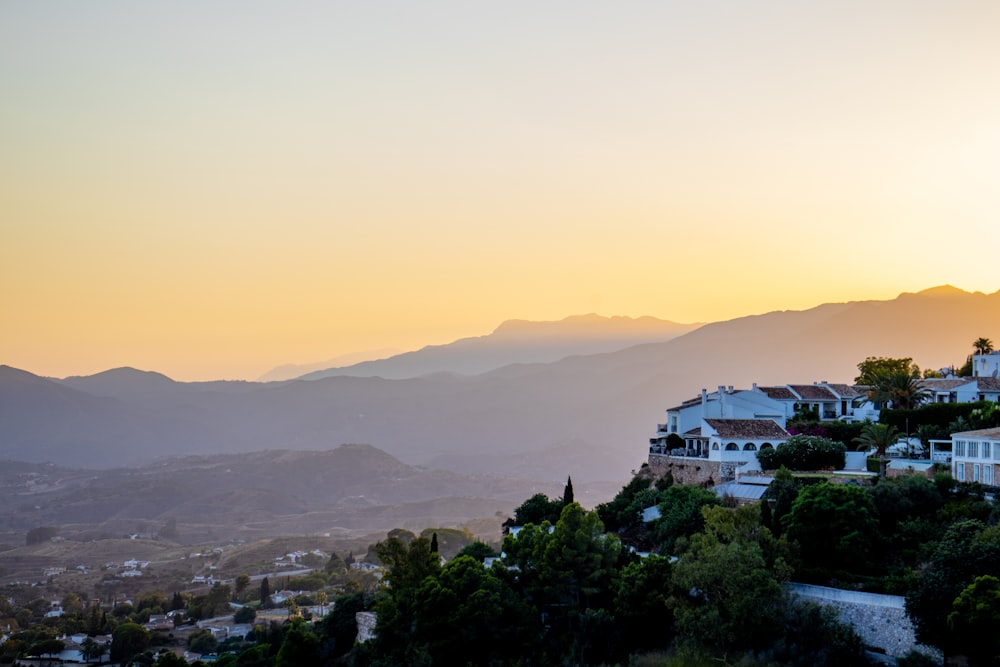 Una vista del atardecer de una ciudad con montañas al fondo