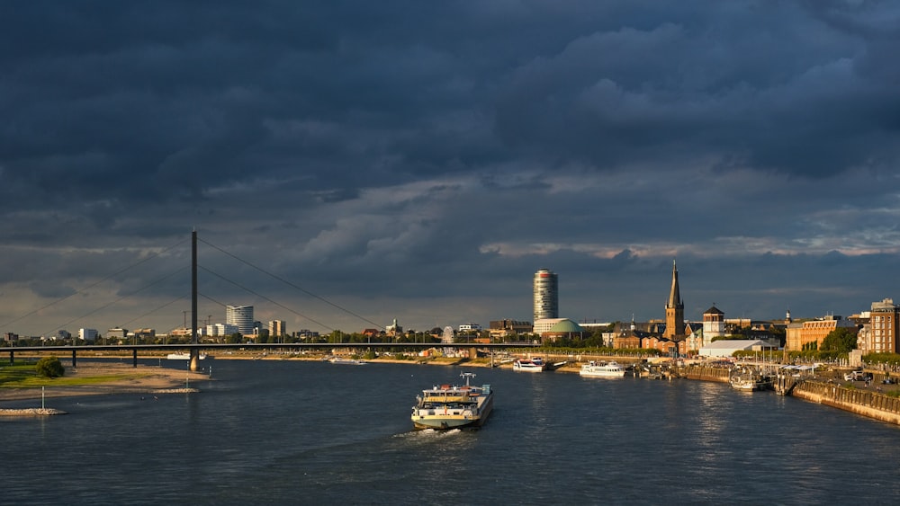 a boat traveling down a river under a cloudy sky