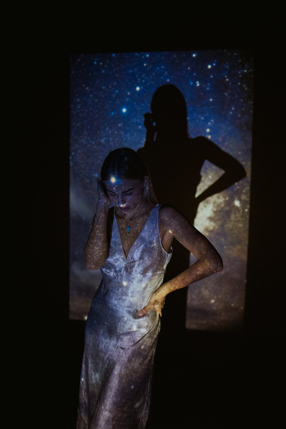 a woman standing in front of a projection screen