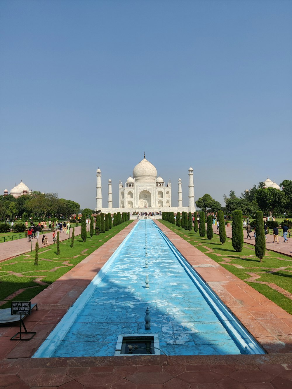 a long pool of water in front of a white building