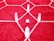 Clear quartz crystals arranged on a red rug with a white geometric pattern. The crystals are positioned in a symmetrical formation, creating a visually striking arrangement.