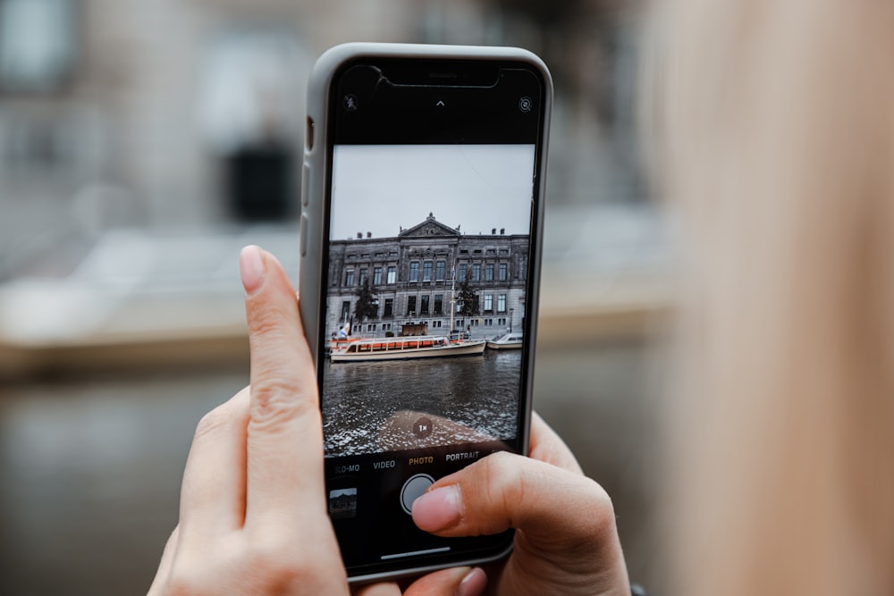 a woman taking a picture of a building with her cell phone