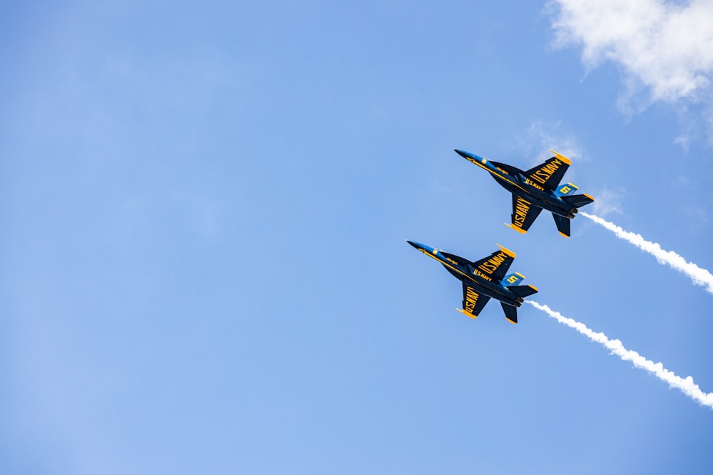 two fighter jets flying through a blue sky