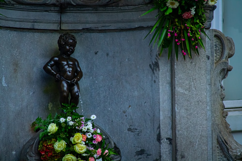 eine Statue eines Jungen, der einen Blumenstrauß hält