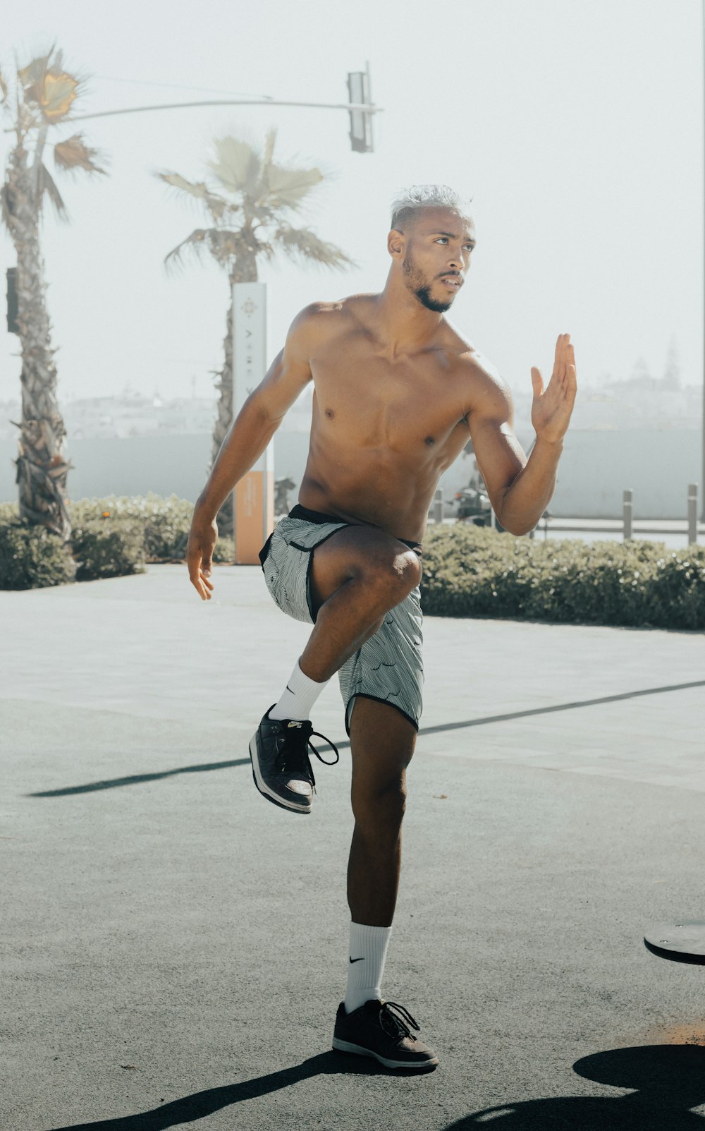 a shirtless man is playing tennis on a court