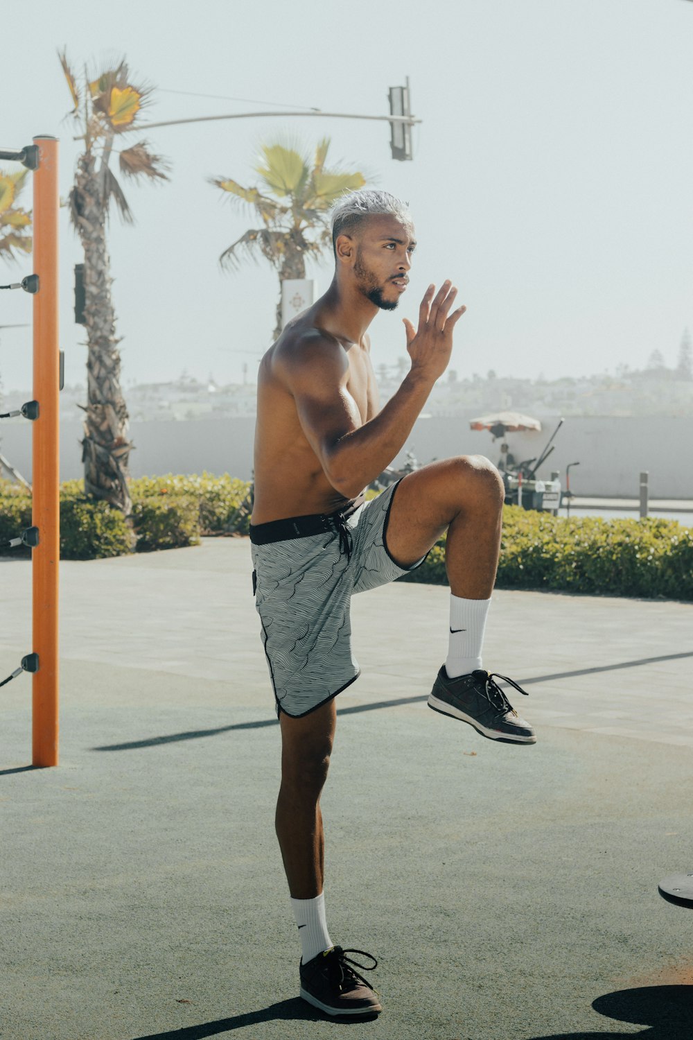 a shirtless man doing a trick on a basketball court