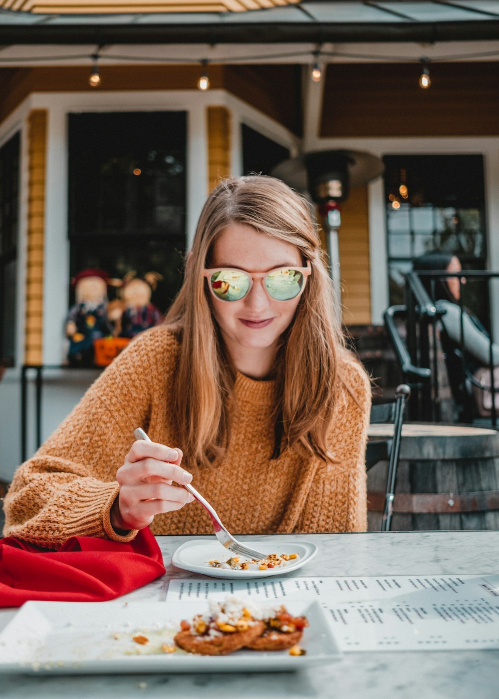 a woman sitting at a table with a plate of food