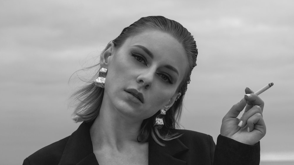 a woman smoking a cigarette on the beach