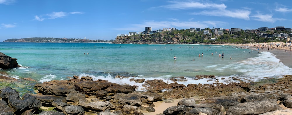 a beach with people swimming in the water