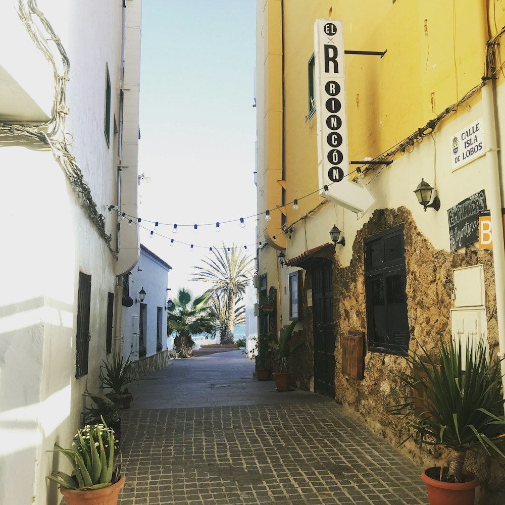 a narrow street with a sign on the side of it