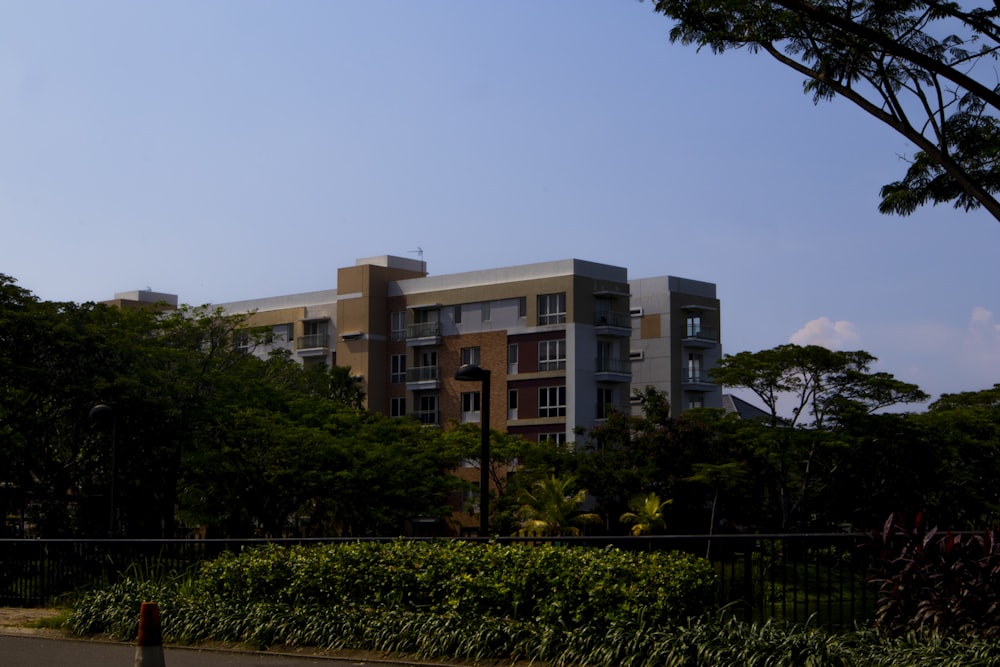 a tall building sitting next to a lush green forest