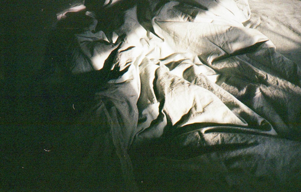 a person laying in a bed with a white sheet