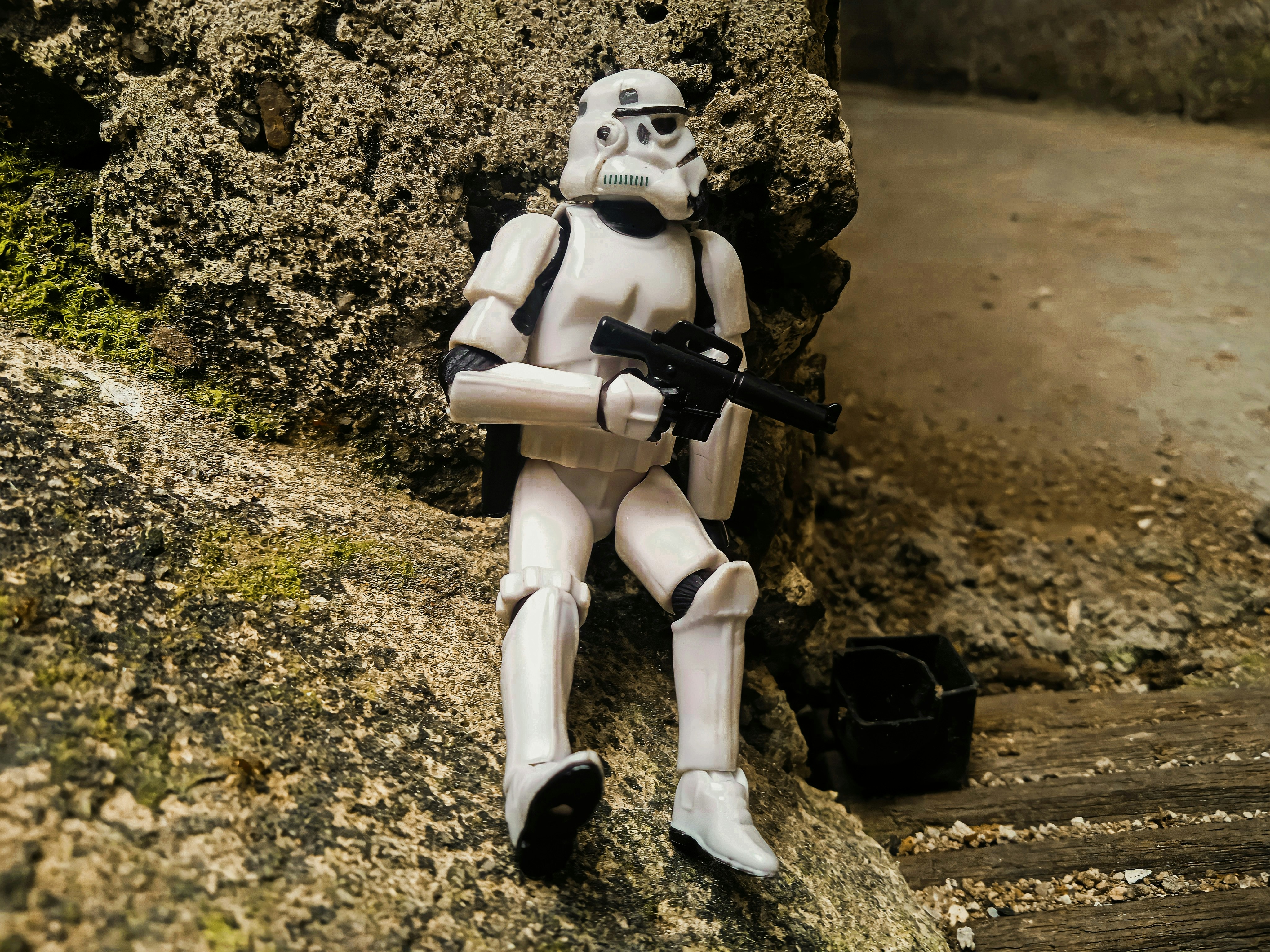 a star wars action figure sitting on a rock