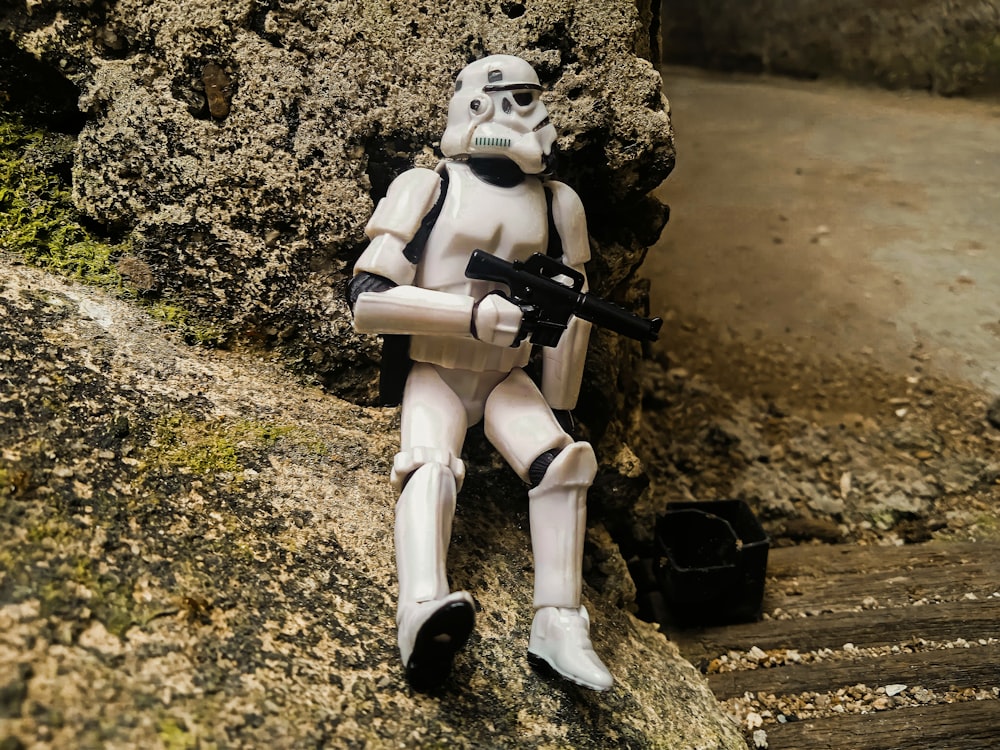 a star wars action figure sitting on a rock