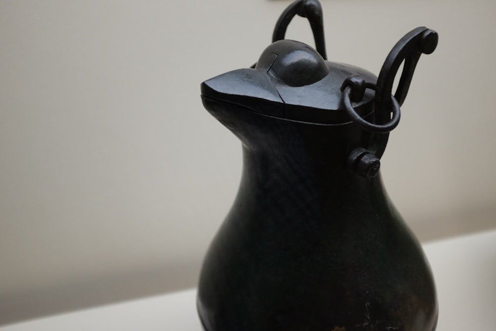 a black vase sitting on top of a table