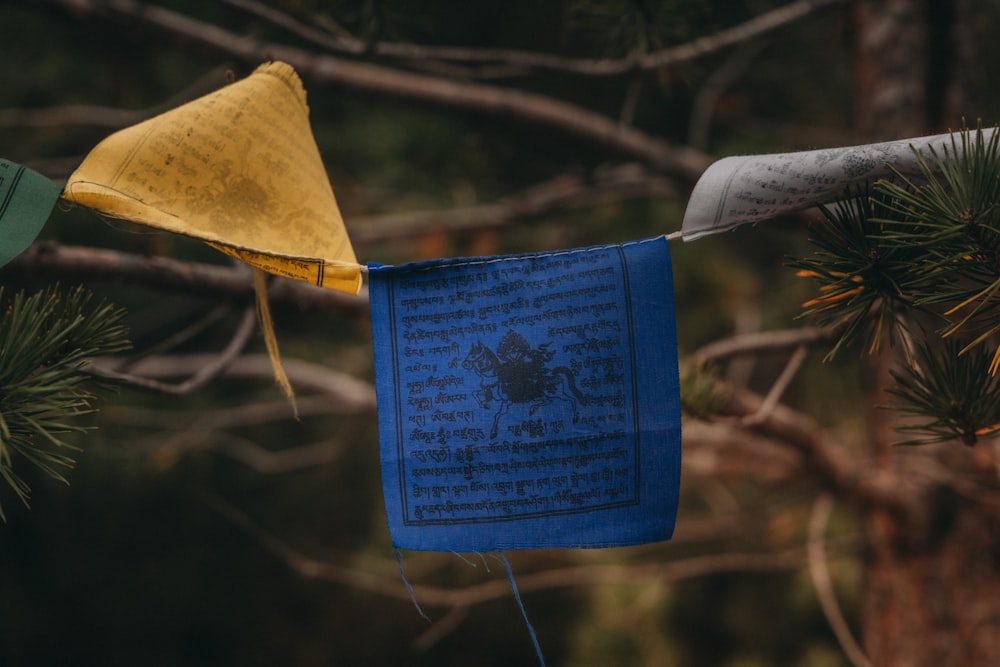 a blue and yellow cloth hanging from a tree